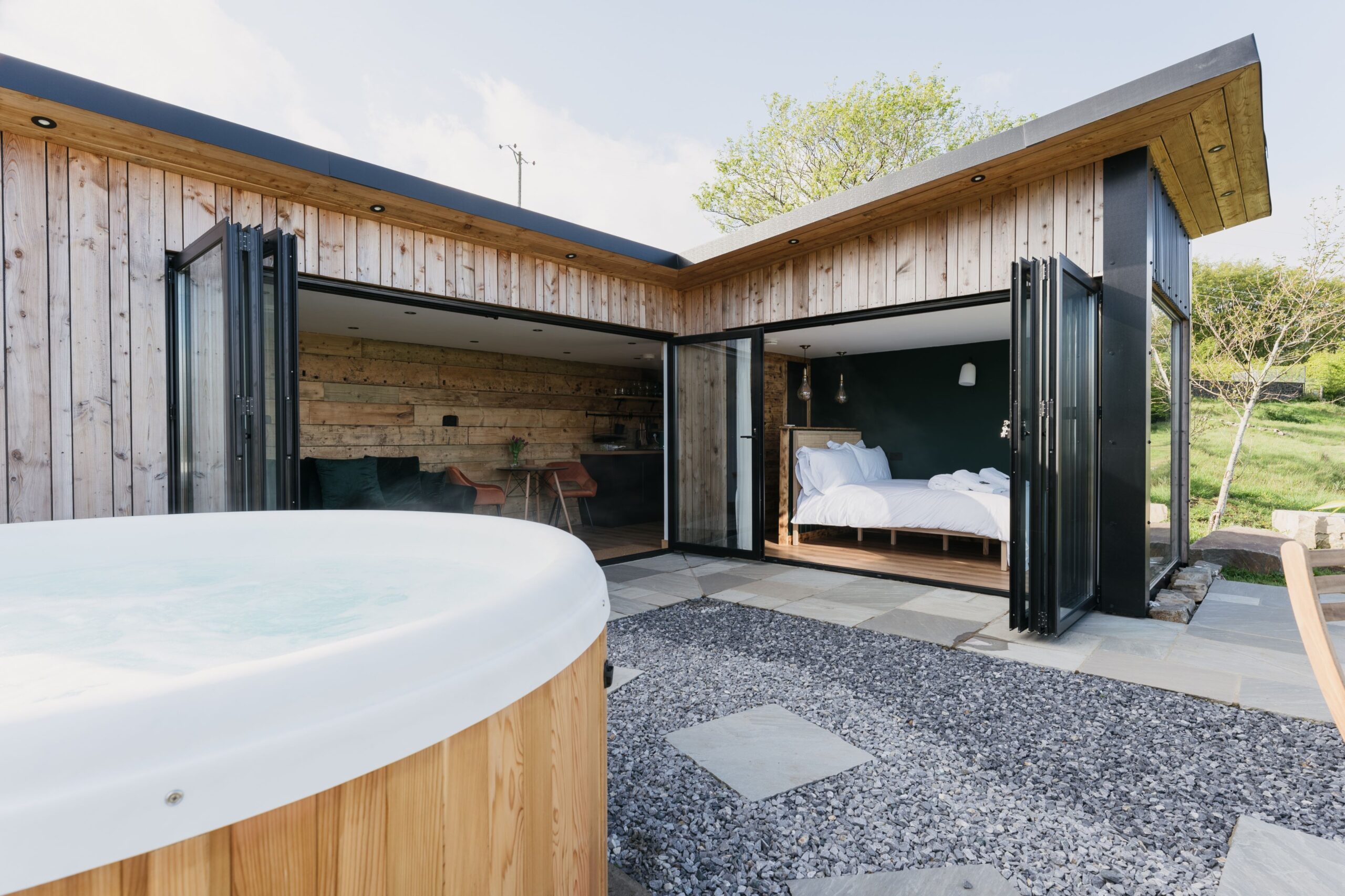 A wooden hot tub outside of a house